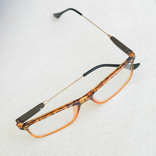 An image of red reading glasses on a tabletop.