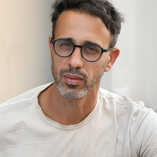 man wearing small round readers
